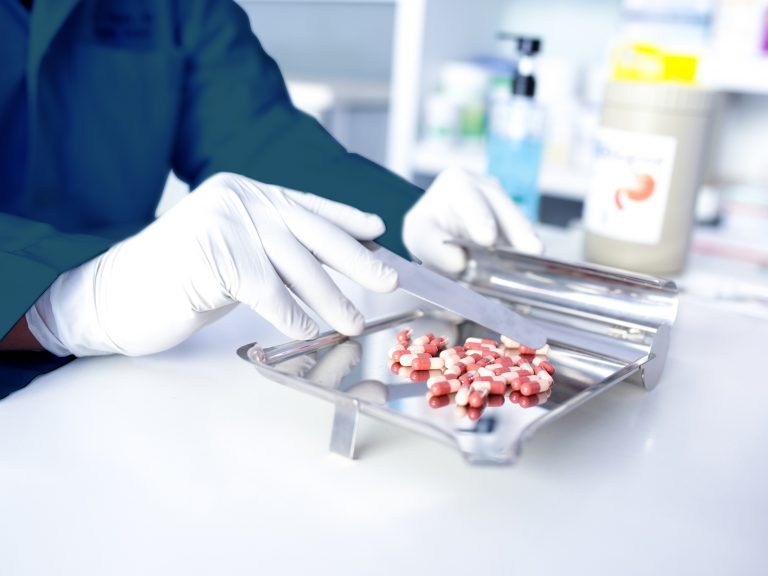 A doctor dispensing pills onto a tray