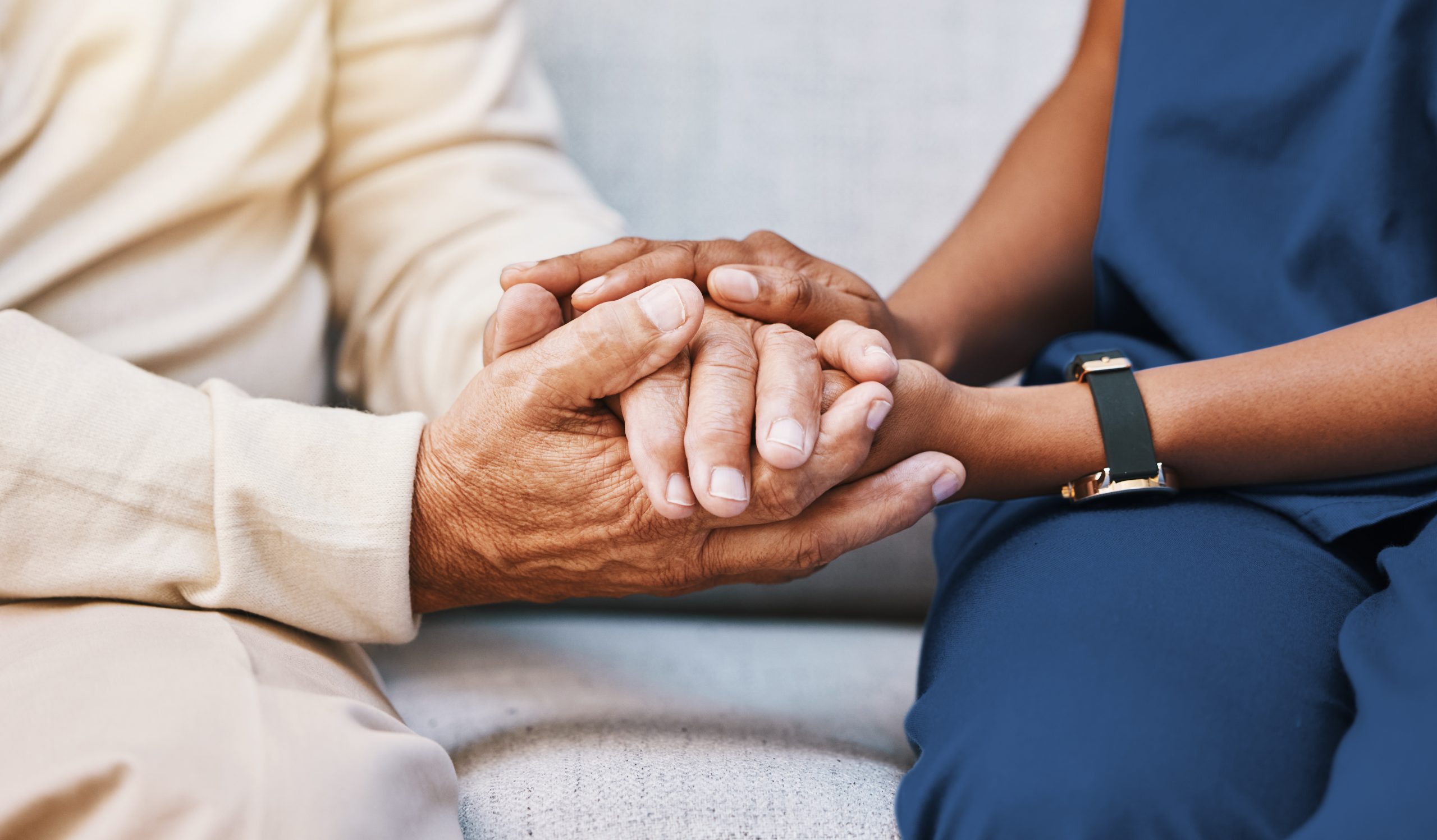 Nurse and senior patient holding hands