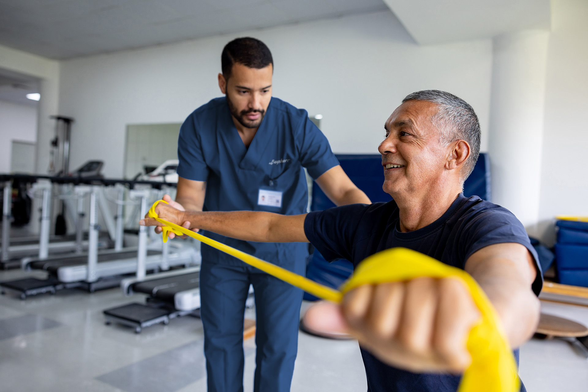 Homme faisant des exercices de physiothérapie à l’aide d’une bande élastique