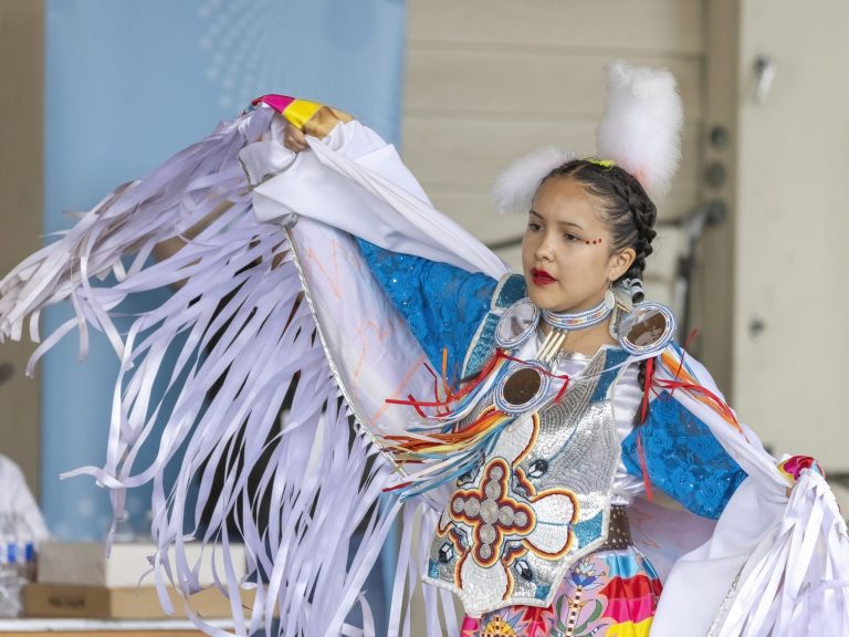 An indigenous woman wearing a white traditional dress