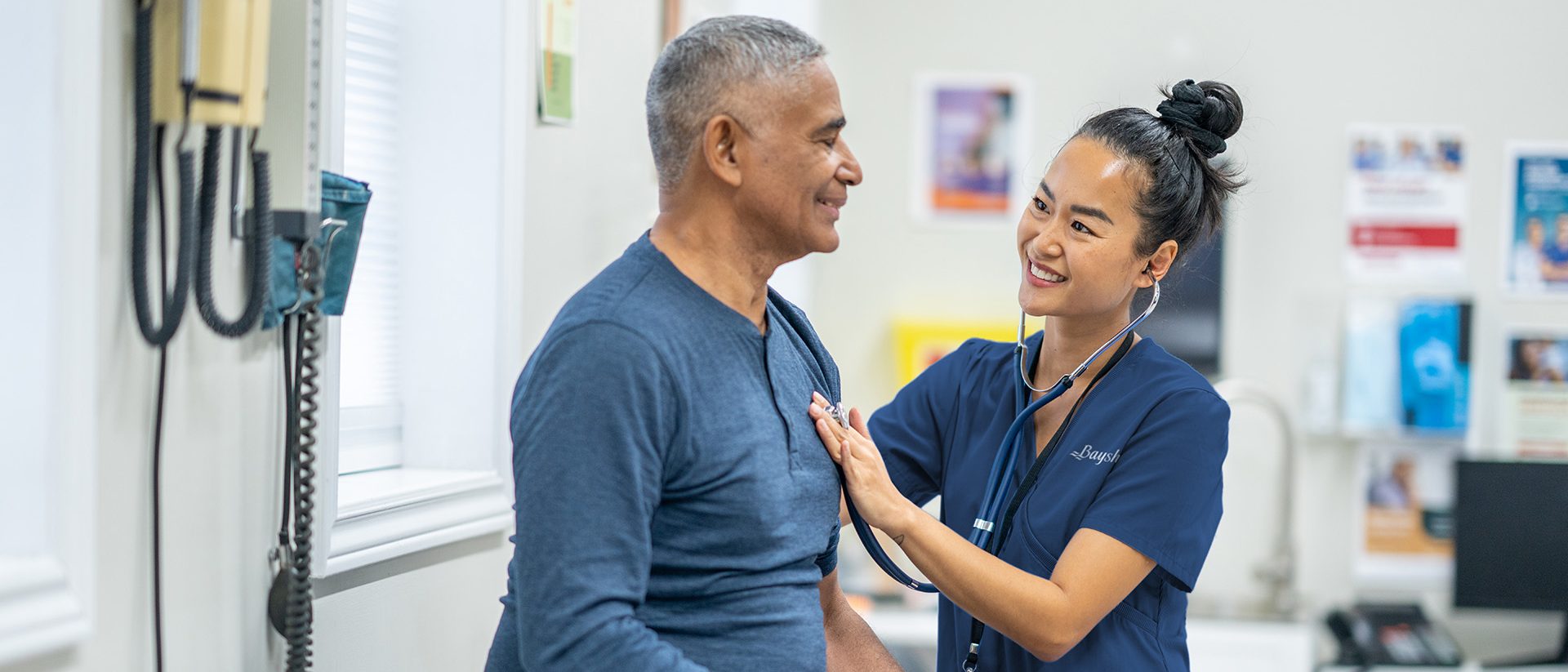 Une infirmière écoute le cœur d'un homme à l'aide d'un stéthoscope