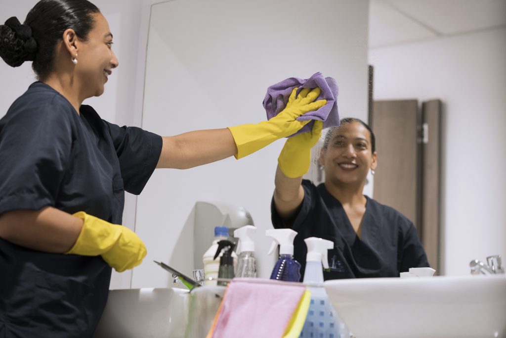 Woman cleaning the bathroom mirror